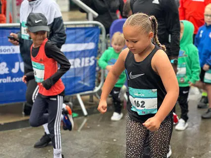 Two children running side by side in a race