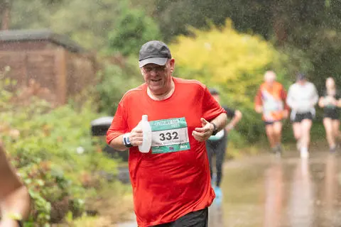 A person running on a countryside lane in the rain