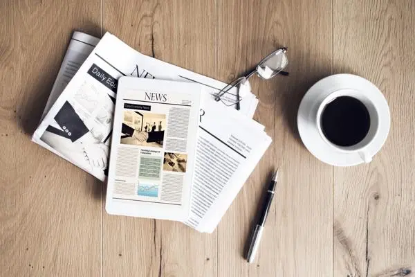 Newspaper with coffee pen and glasses