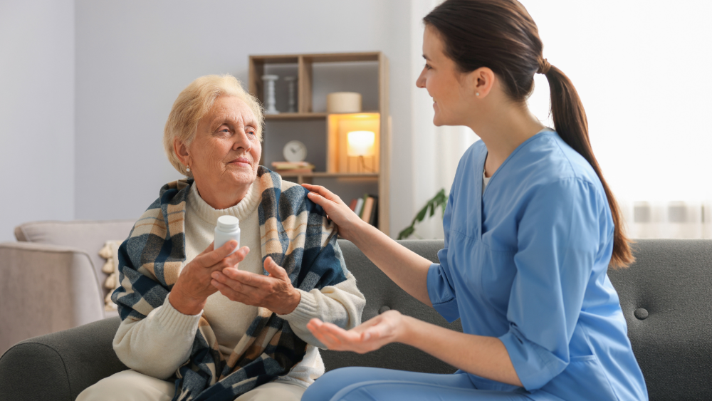 A nurse talking to an older lady who is holding a jar of tablets.