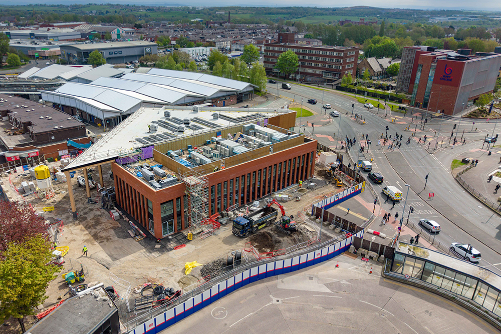 A large building alongside a major road and surrounded by other large buildings