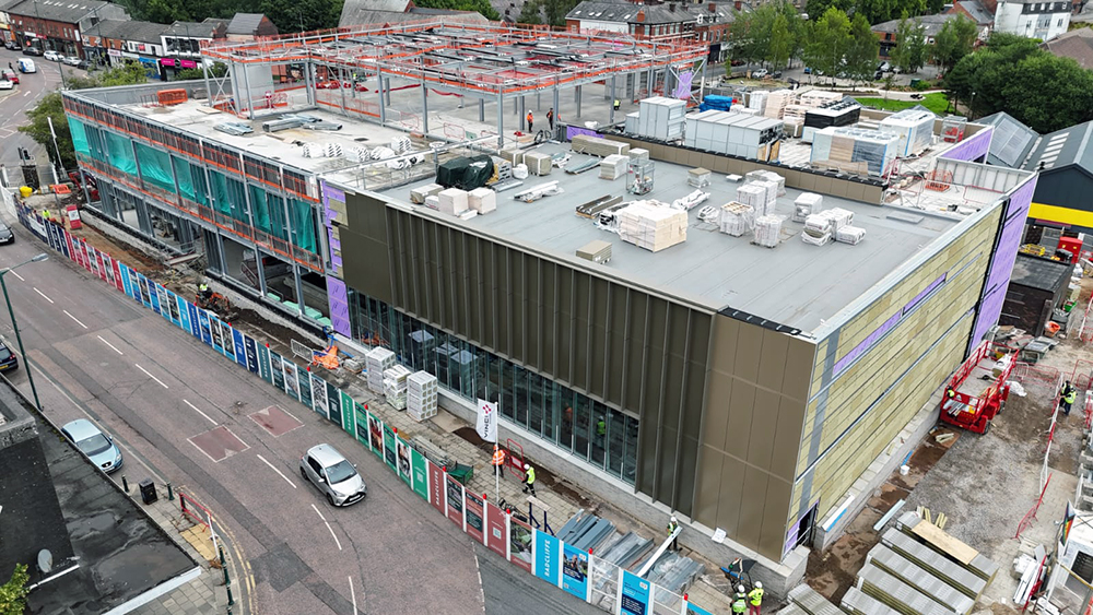 A large building on a construction site surrounded by a road