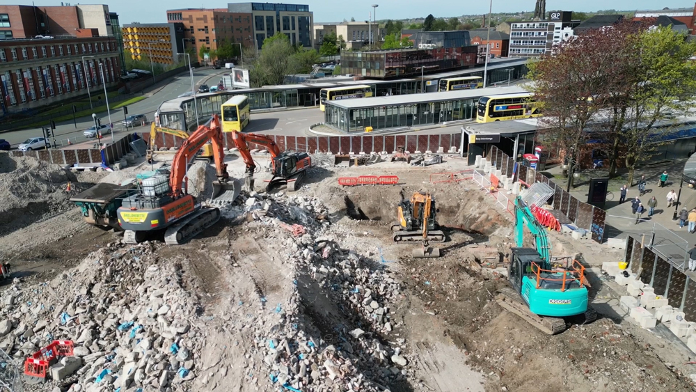 Aerial view of a construction site next to a bus station