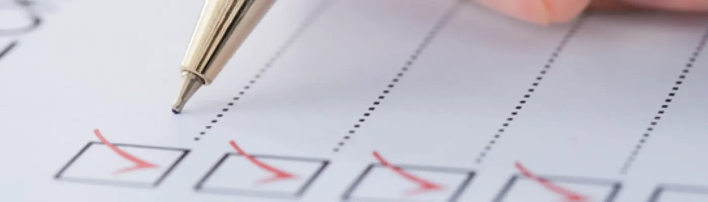 Small boxes on the left side ticked with a pen posed above the paper.