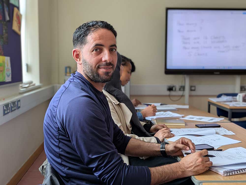 A person sat at a desk in a classroom