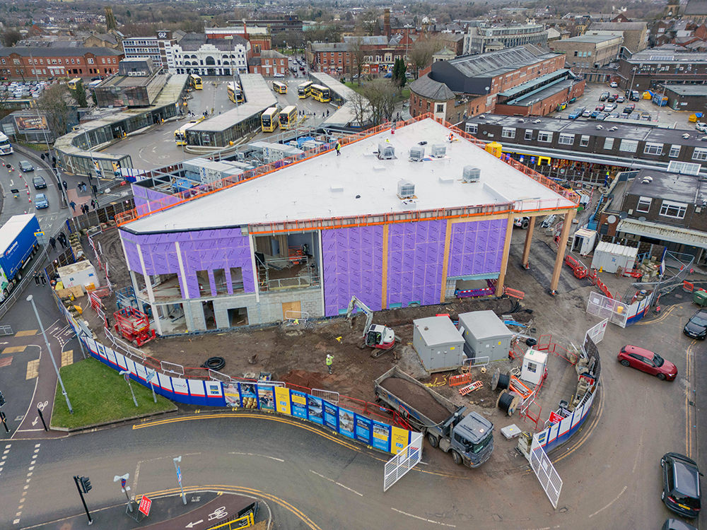 An aerial view of a large building under construction site in a town centre