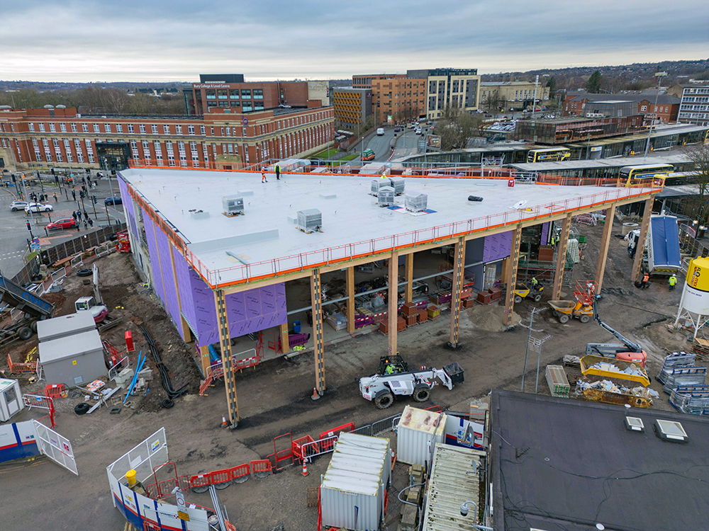 An aerial view of a large building under construction site in a town centre