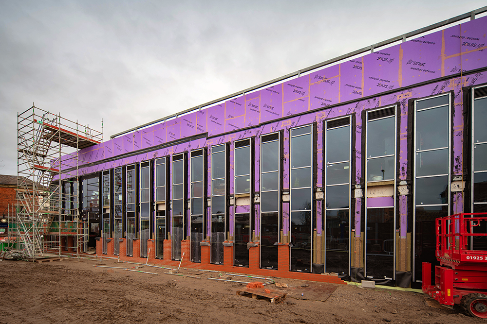 A large building that is under construction with scaffolding attached