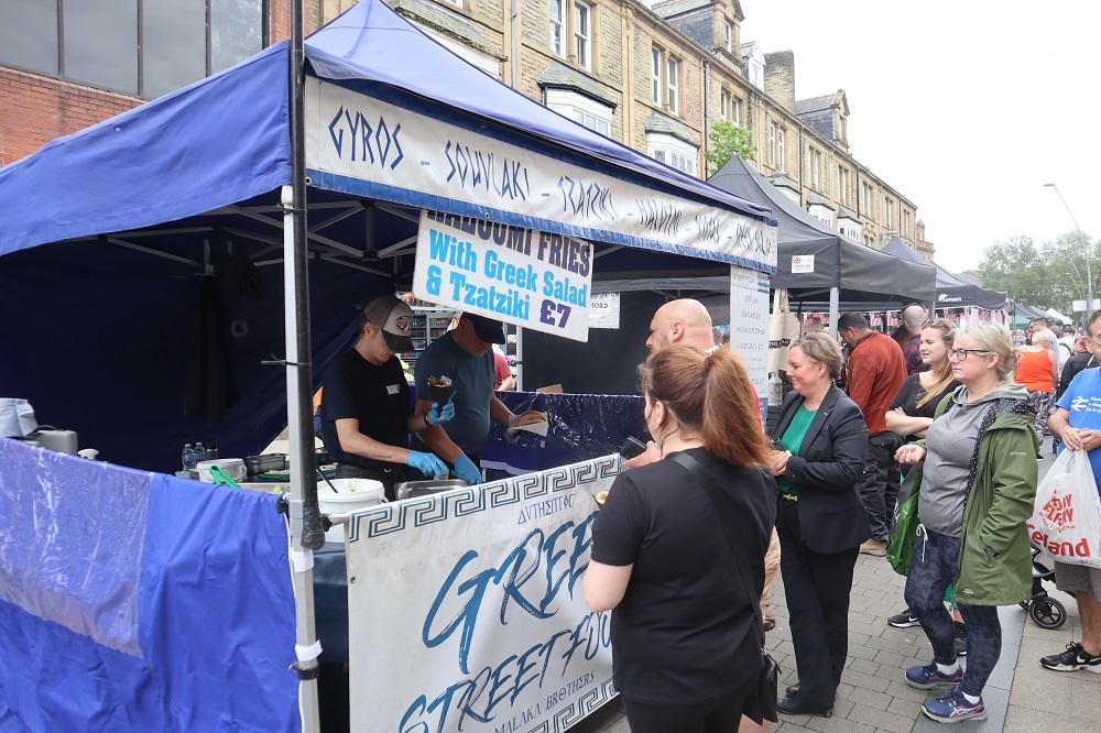 People buying food from a stall.