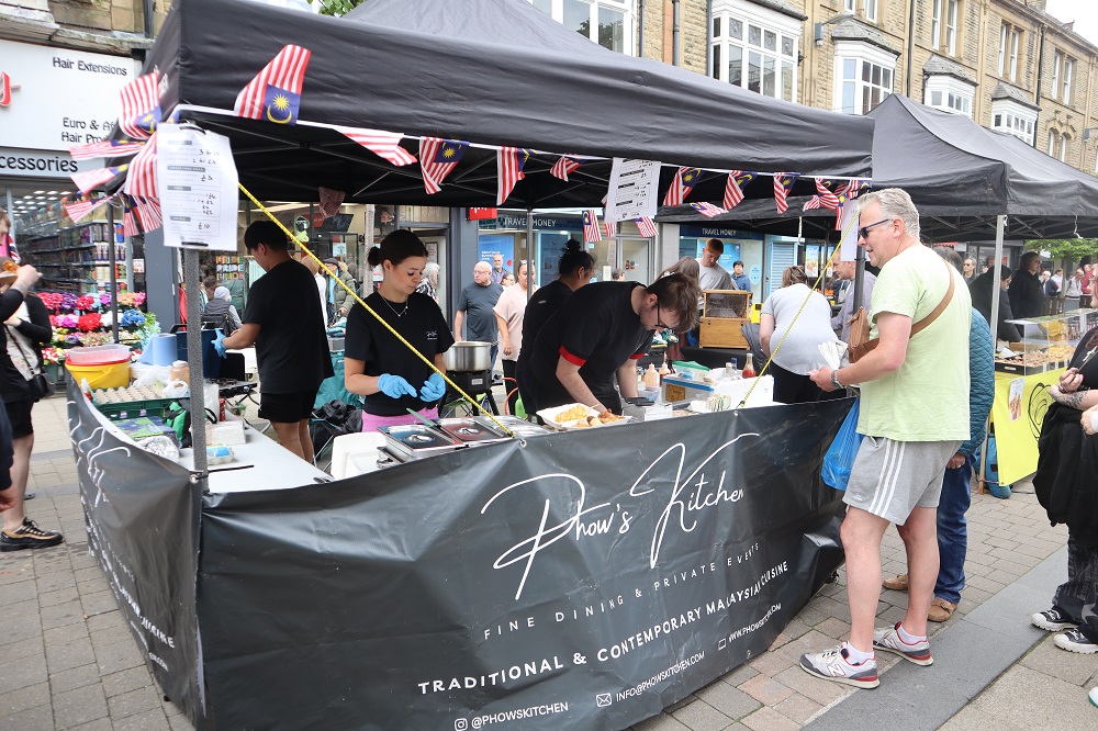 People queuing to buy food from a stall.