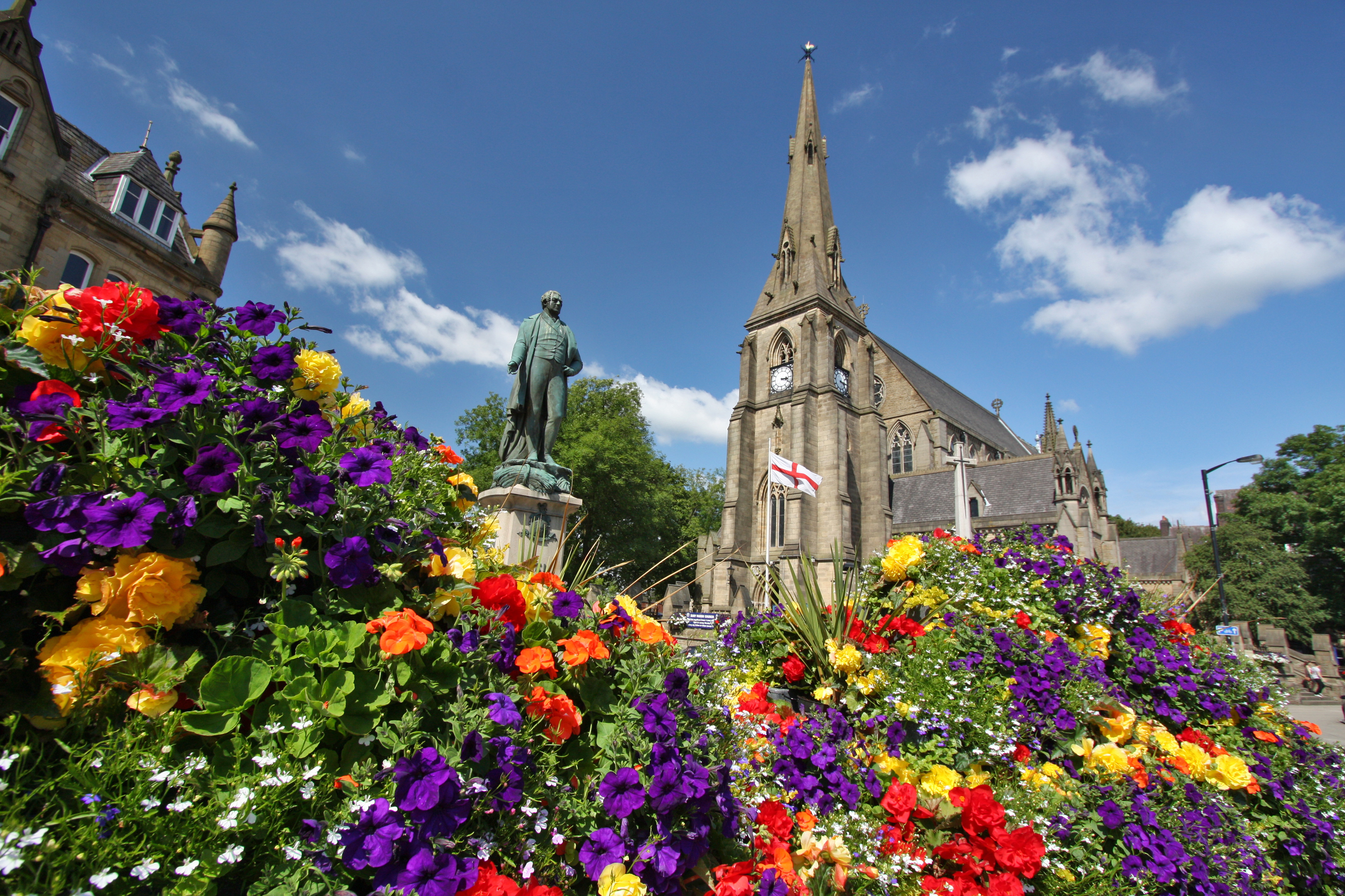 Lots of multi-coloured flowers in front of a church