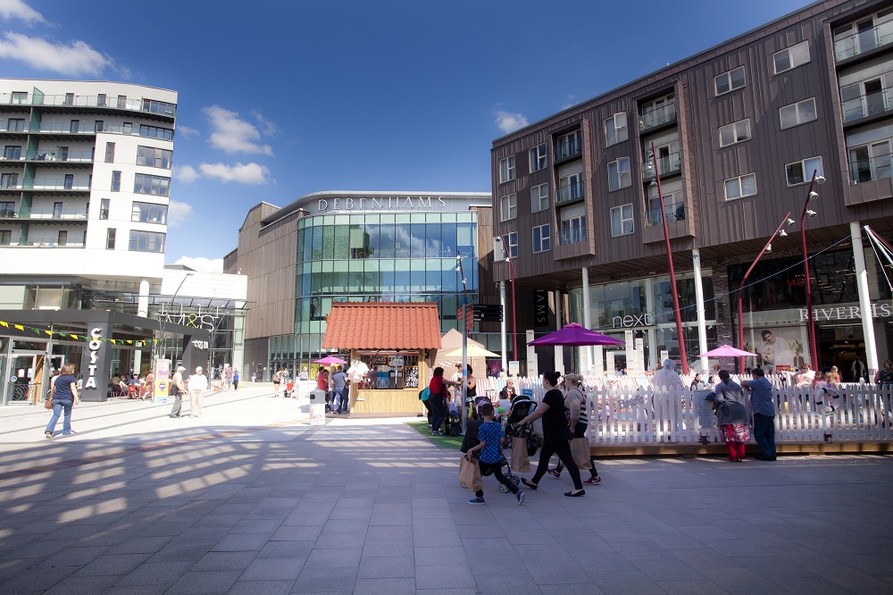 Shops and flats in a square with people