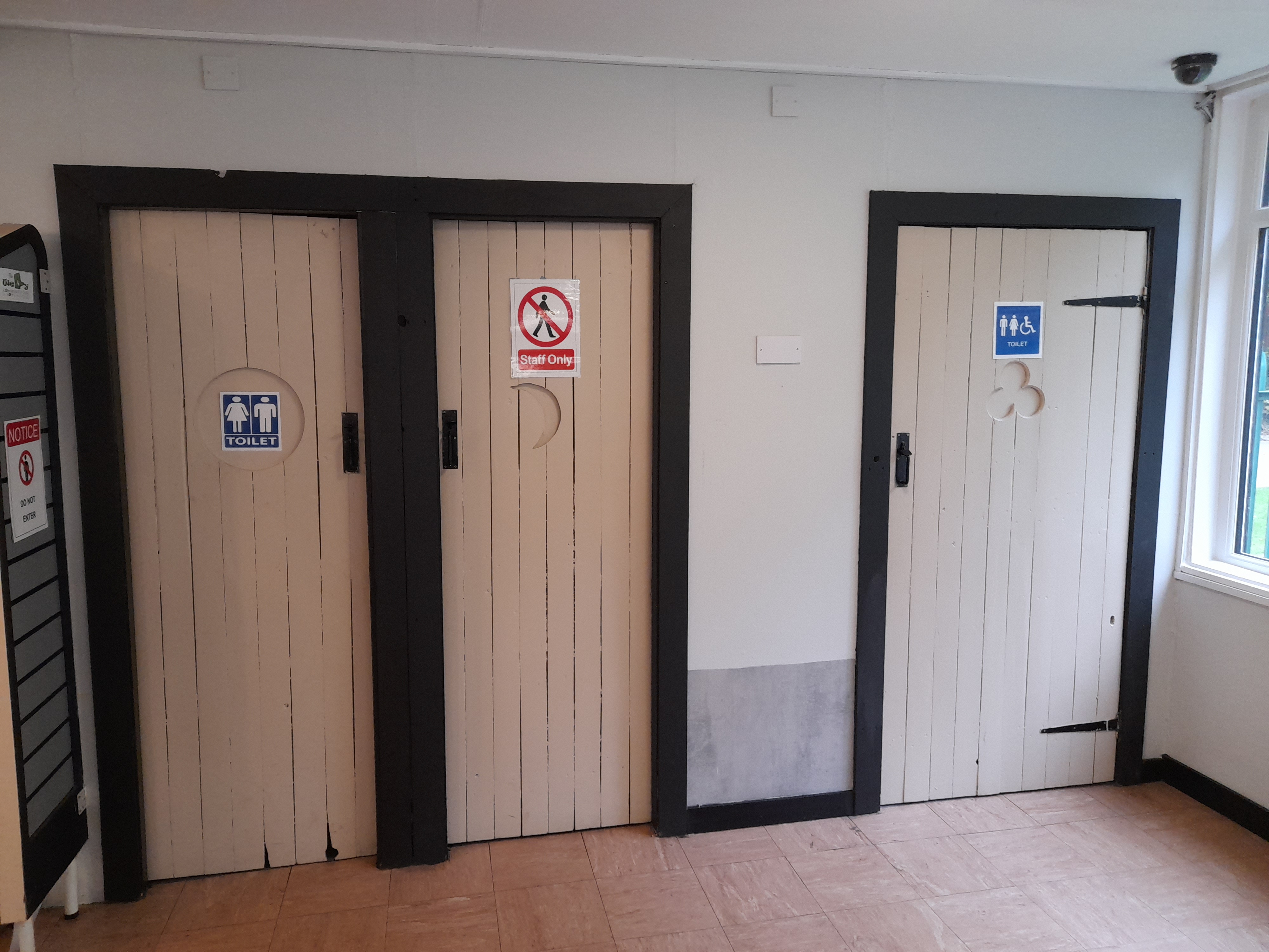 Three doors with toilet signs on them.