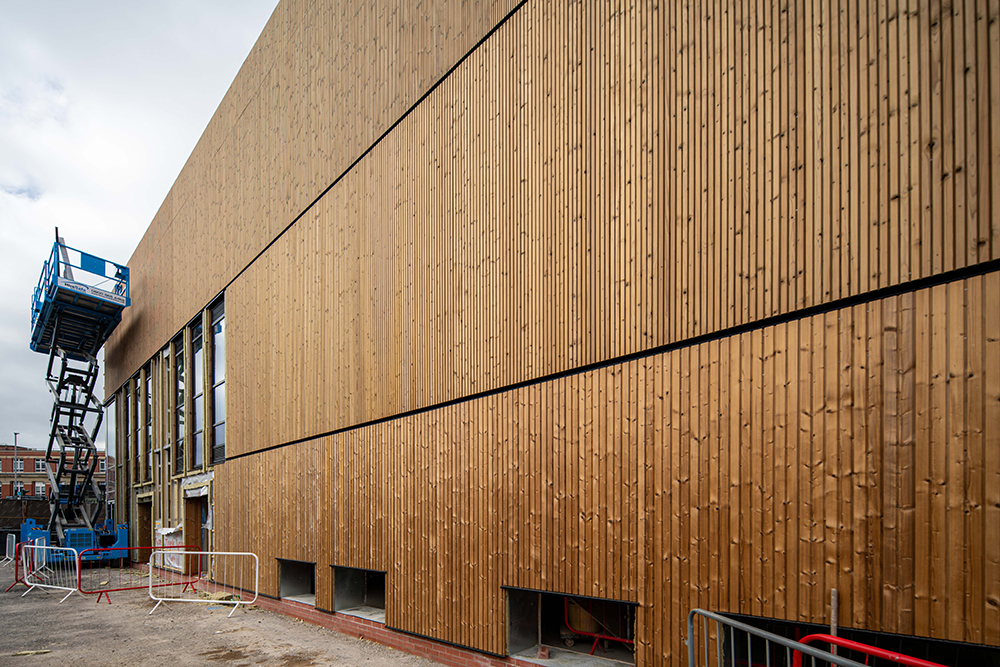 The side of large building covered in timber cladding