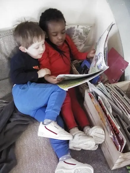 two children reading a book together