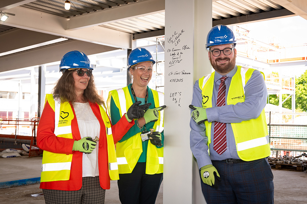 Three people who are pointing at a handwritten message that reads, Lynne Ridsdale CEO, Cllr Eamonn O'Brien, Leader of the Council, Cllr Carol Birchmore, 6/5/25, Lets Do it!