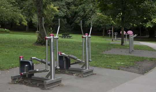 Metal gym equipment by a path,