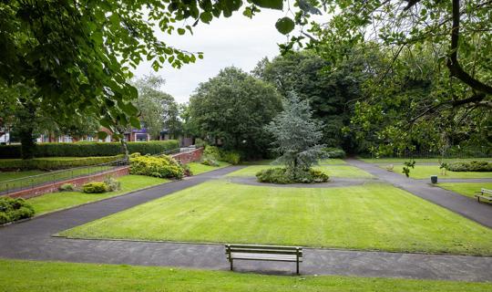 Footpaths, bench, gardens, bushes and trees at Hamilton Rd Park.