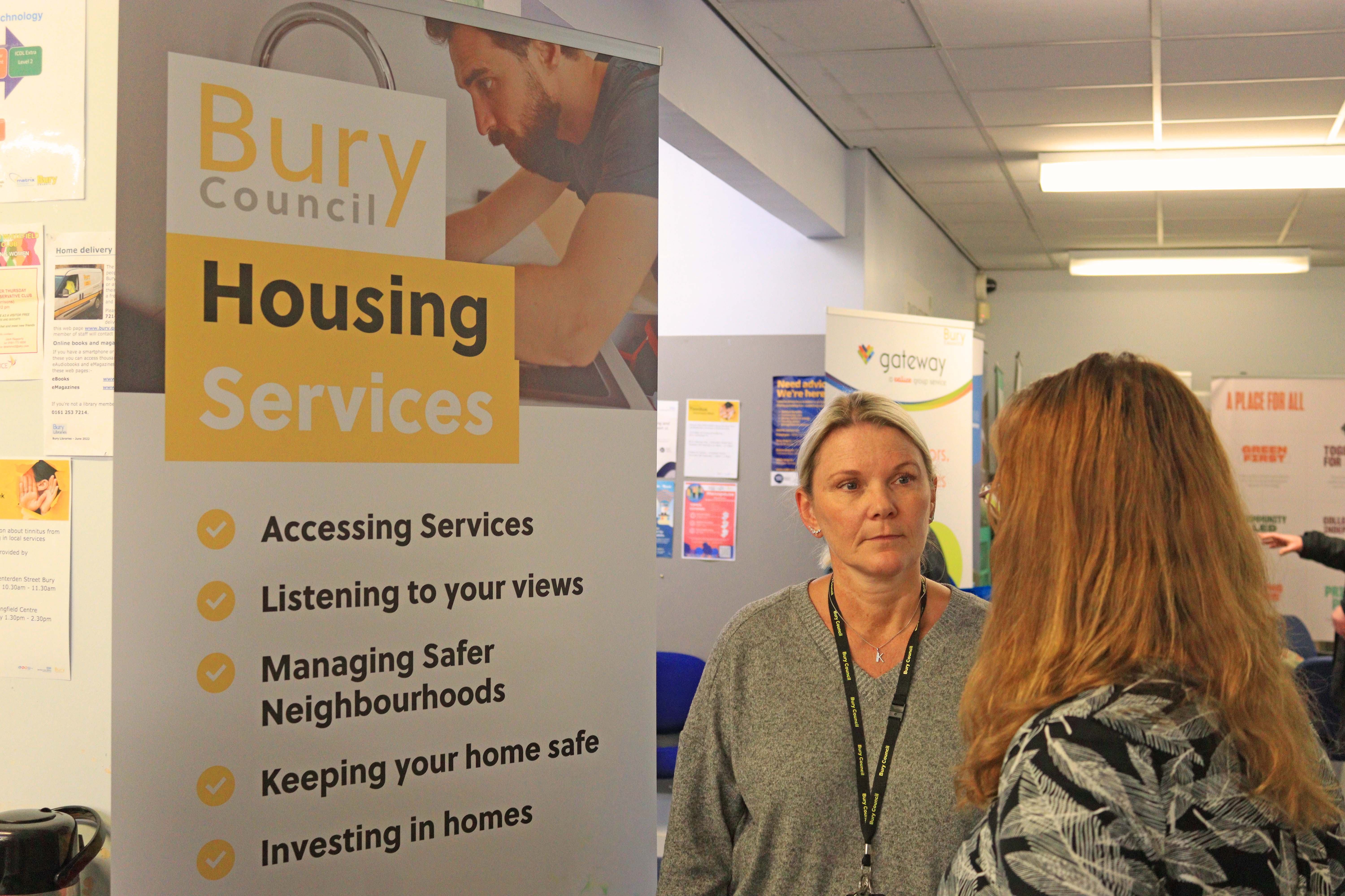 Staff in front of a Bury Housing Services Banner 