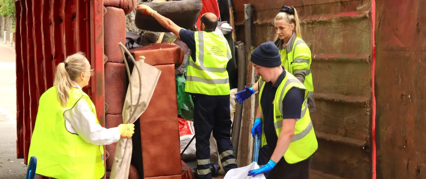 Bury Housing Staff loading a skip with rubbish