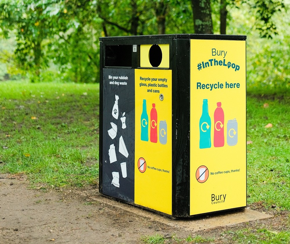 Recycling bin on a path in a park.