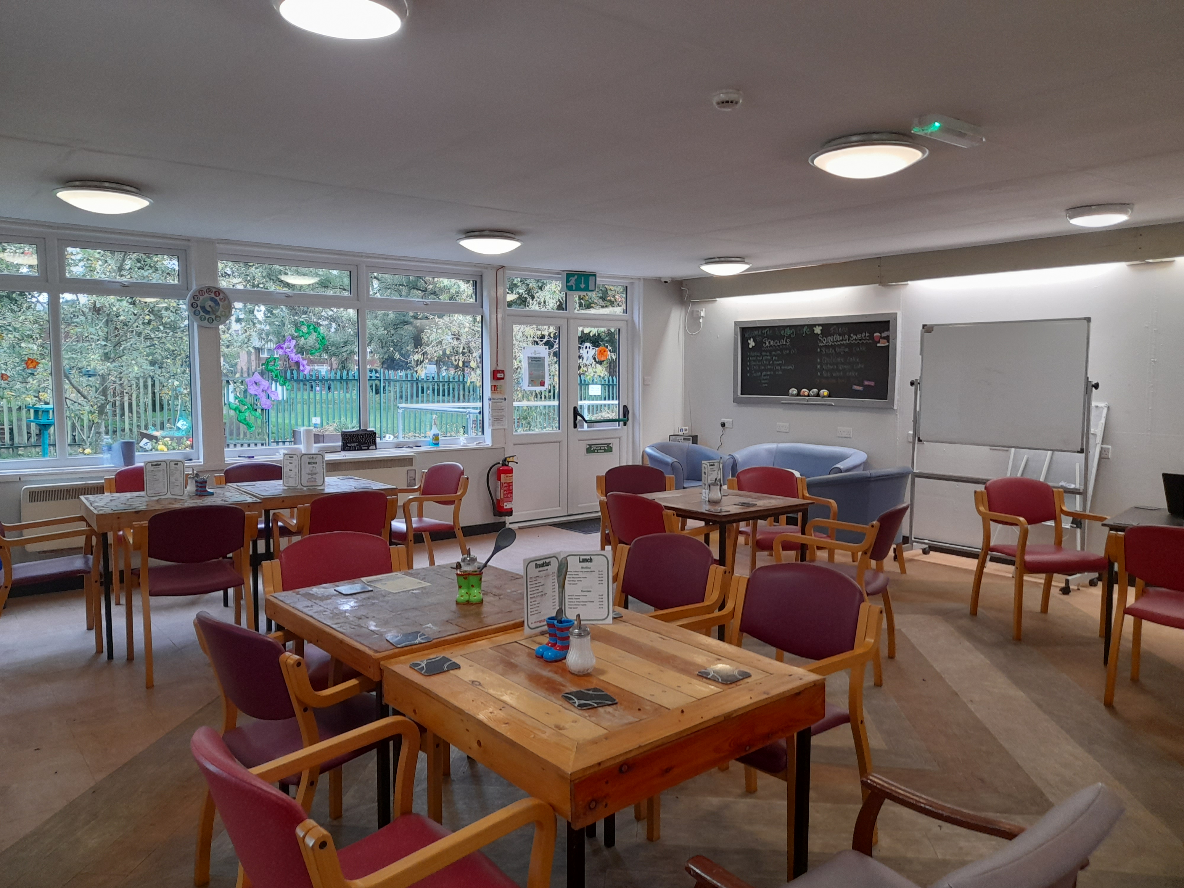 Inside cafe showing tables with chairs grouped around them.