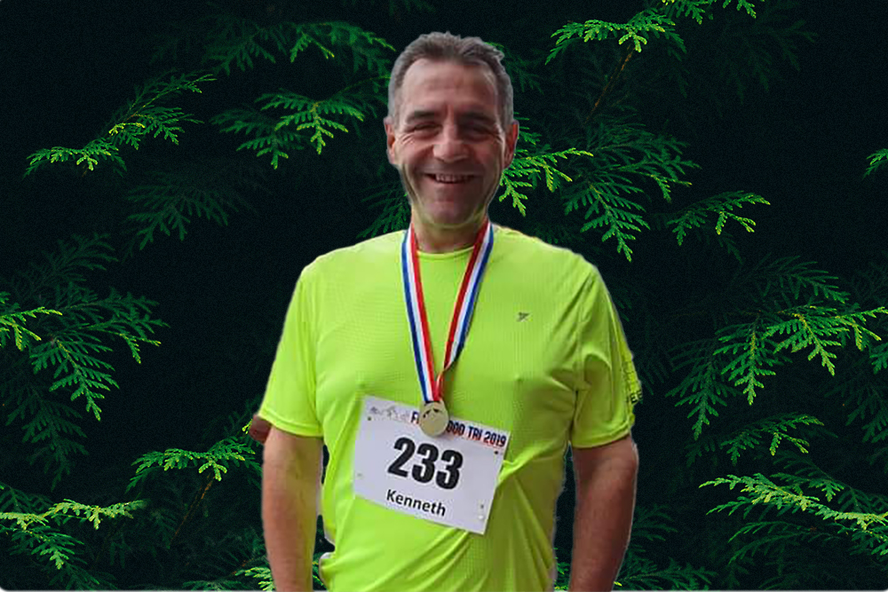 Smiling person wearing a race medal around their neck