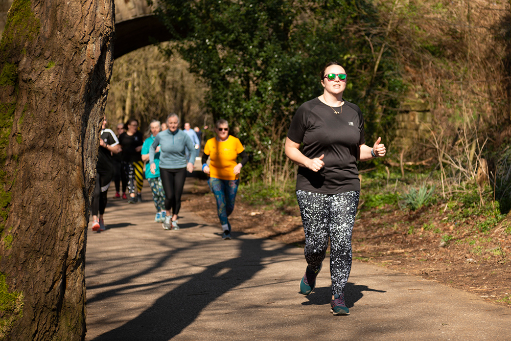 Group of runners on a countryside lane surrounded by trees