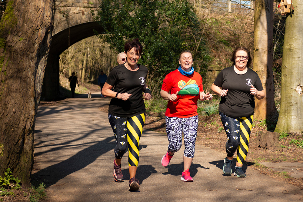 Group of runners on a countryside lane surrounded by trees