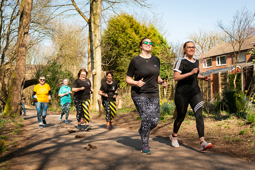 Group of runners on a countryside lane surrounded by trees