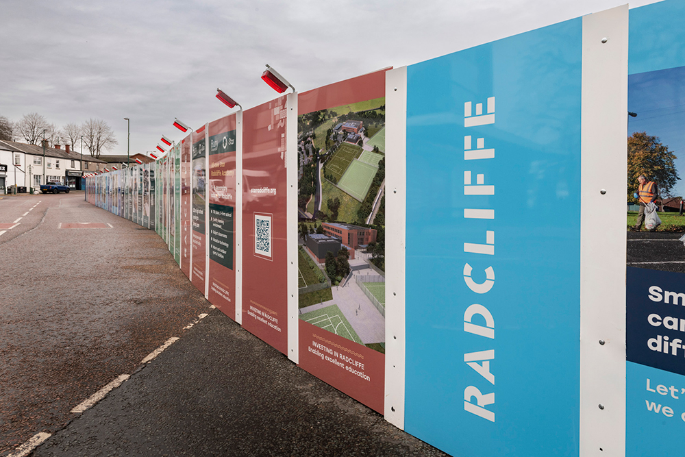 Colourful hoarding panels along a roadside