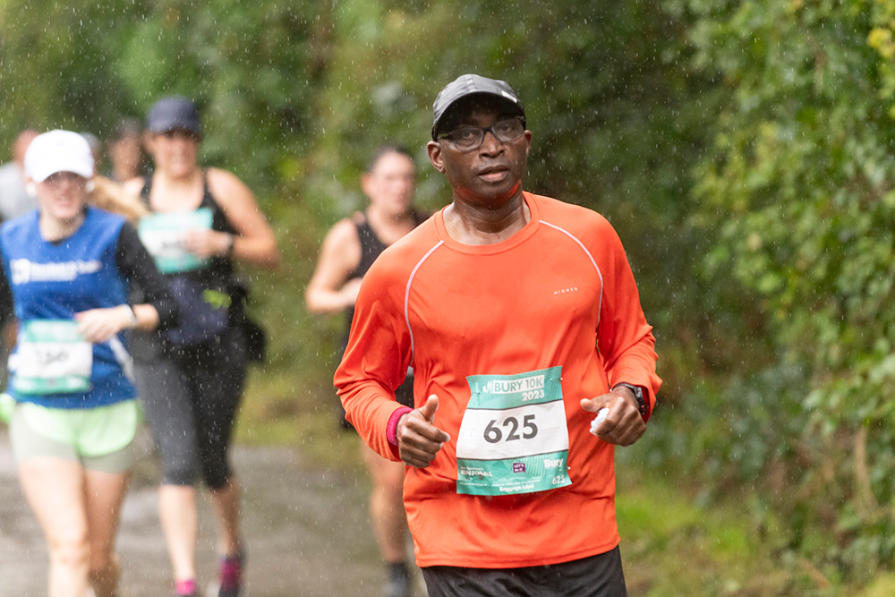 Group of runners on a country lane surrounded by trees