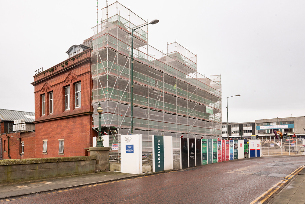 A red brick building with scaffolding covering one wall