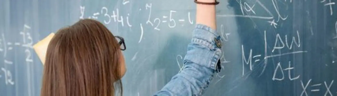 a young person doing maths on a chalkboard