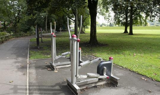 Metal gym equipment next to field.