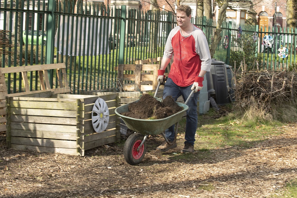 A man pushing a wheelbarrow.