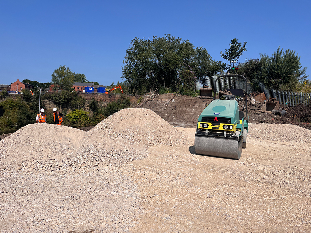 Large piles of gravel and a mechanical roller