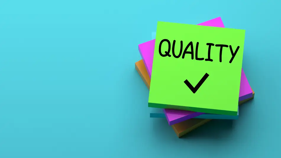 A stack of sticky notes with the world quality on it.