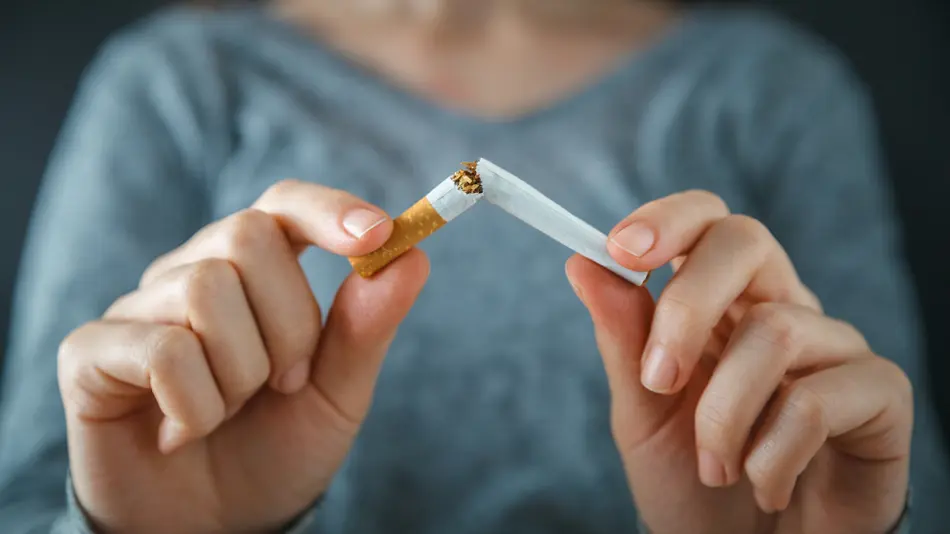 Person snapping a cigarette in half.