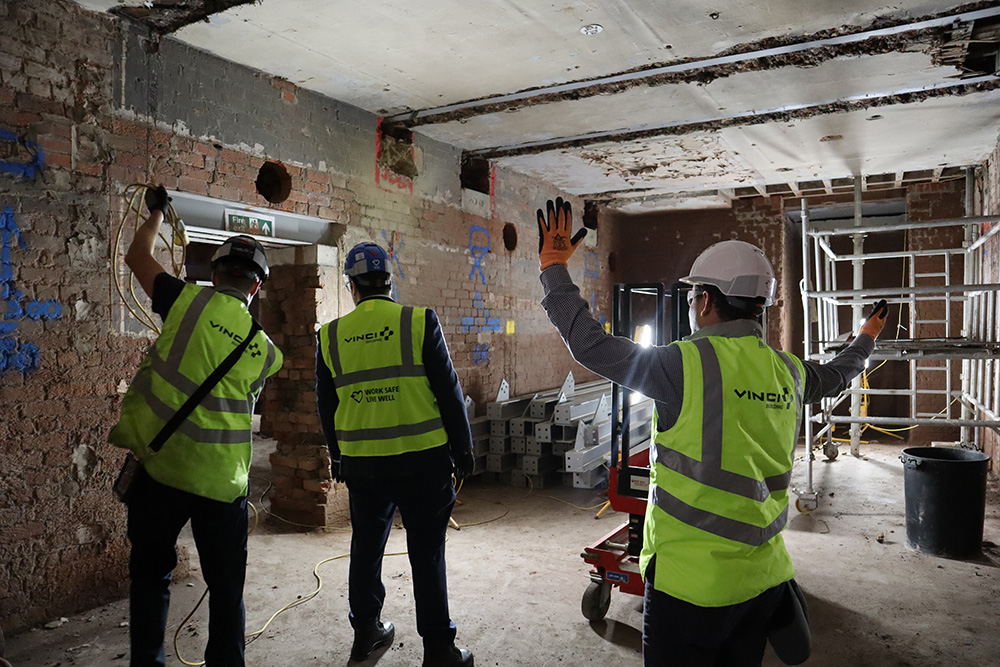 People wearing safety clothing in a buidling basement inspecting building work