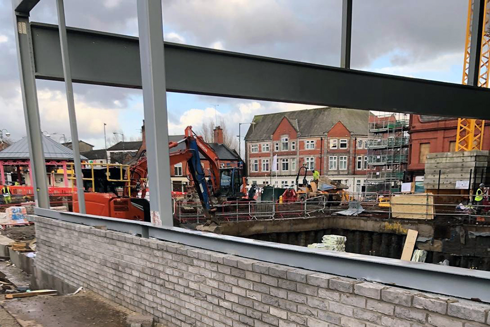 Steel building frame and brick wall on a construction site
