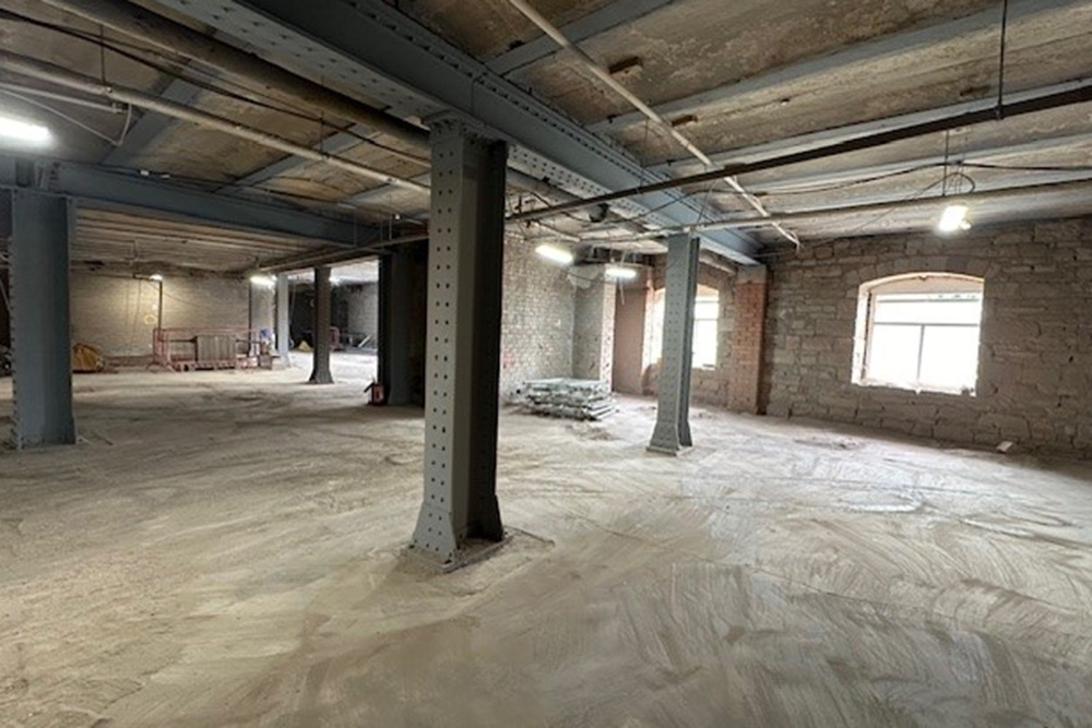 An empty basement with a number of pillars supporting the roof