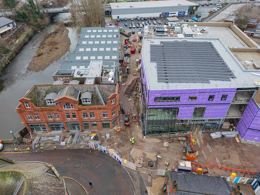 A construction site of a large two-storey building alongside a river