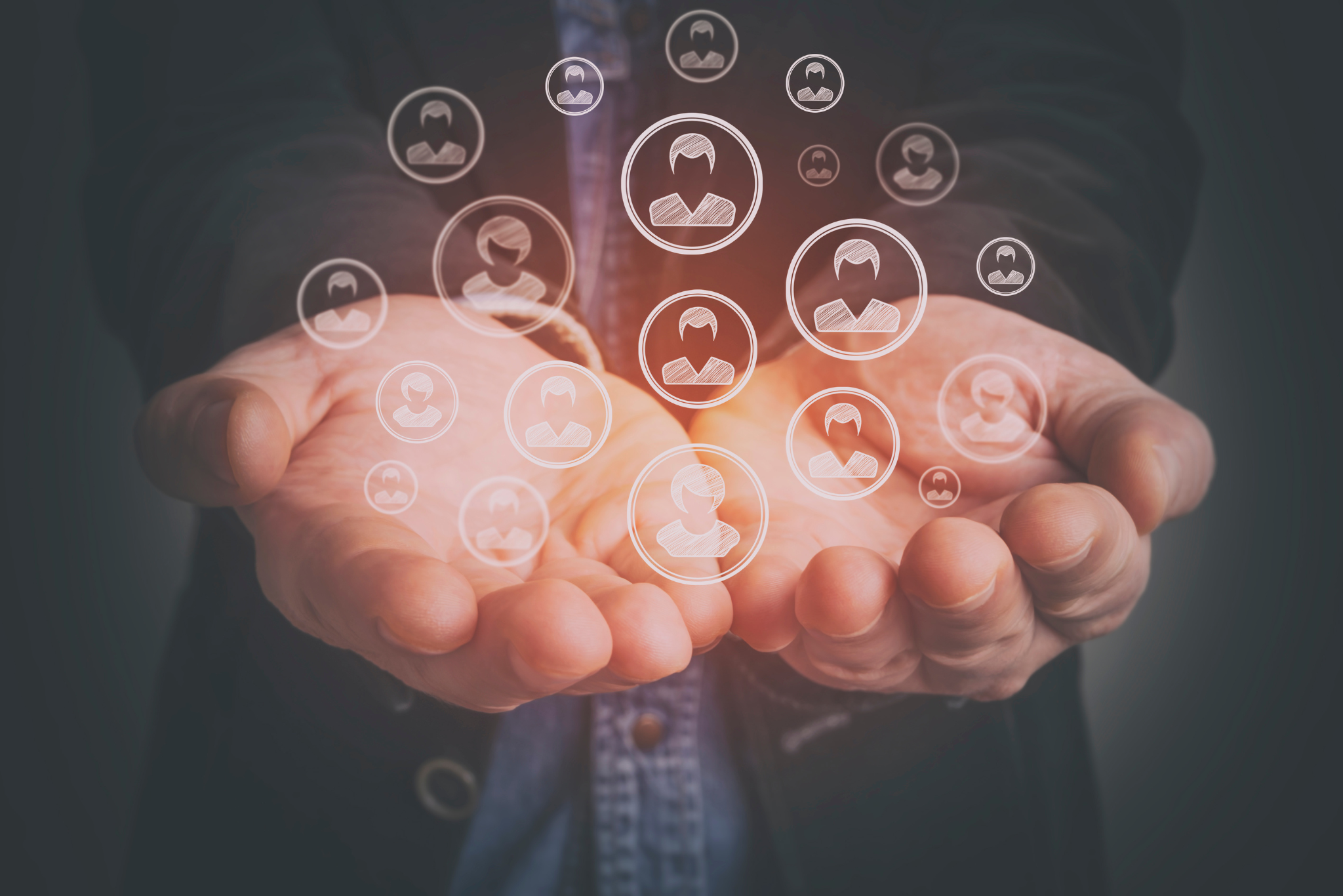 A pair of hands with people floating in bubbles to represent resources