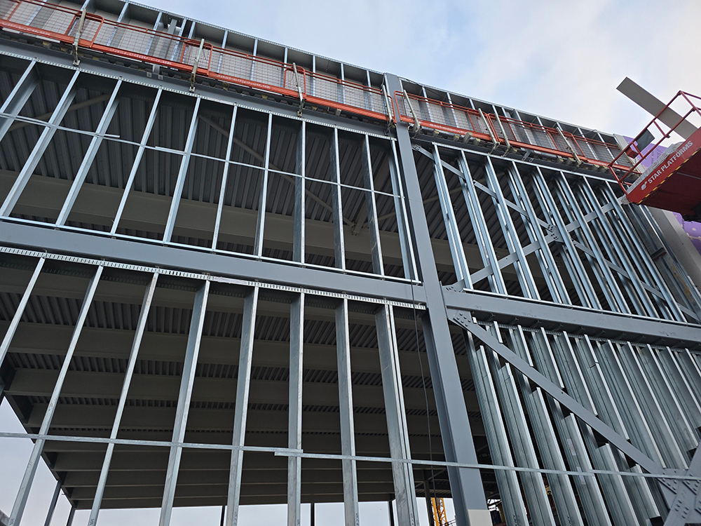 A steel frame on the side of a building that is under construction