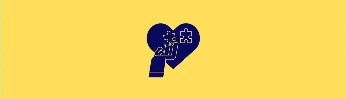 a person fitting the pieces of a heart shaped jigsaw.