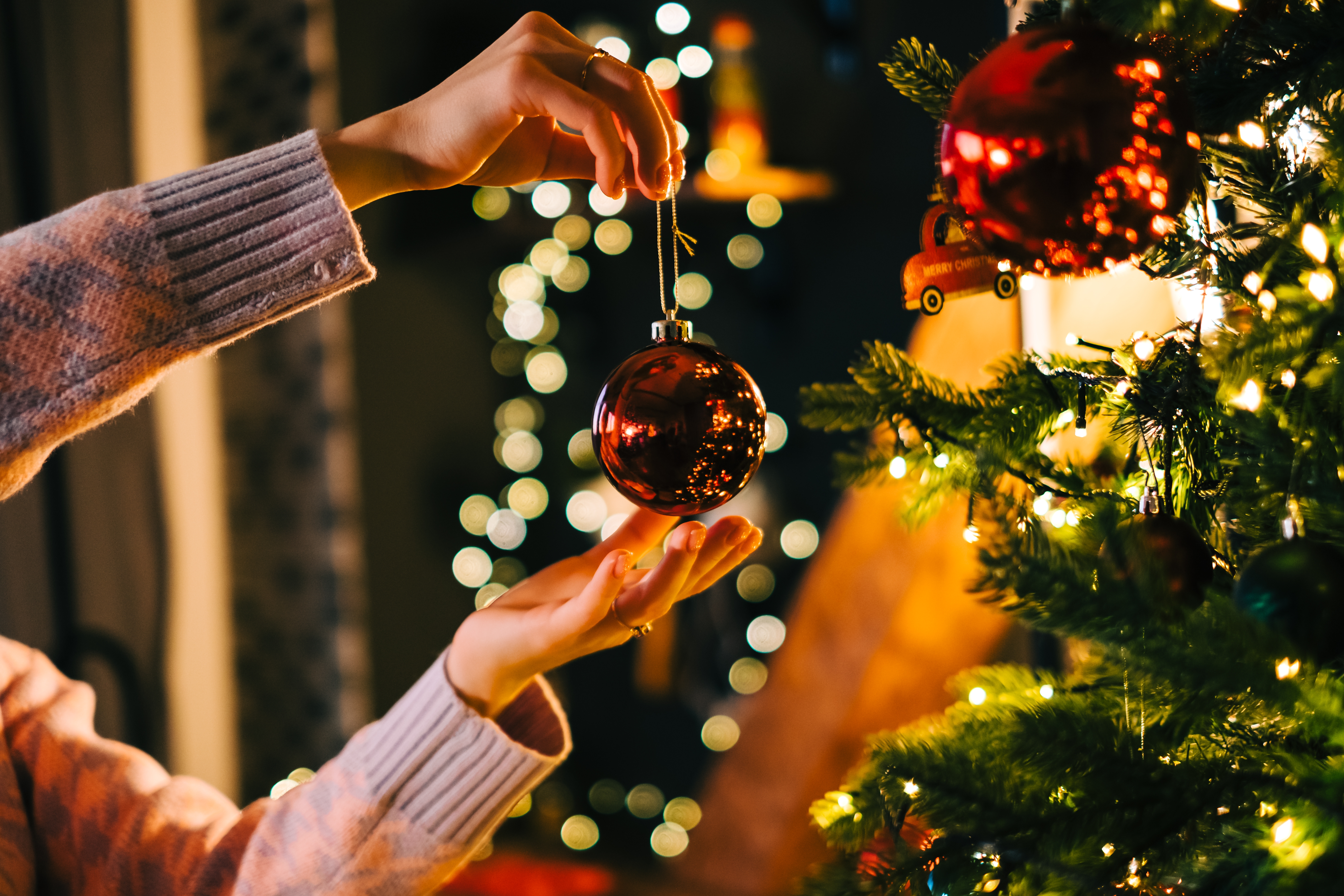 person decorating a Christmas Tree