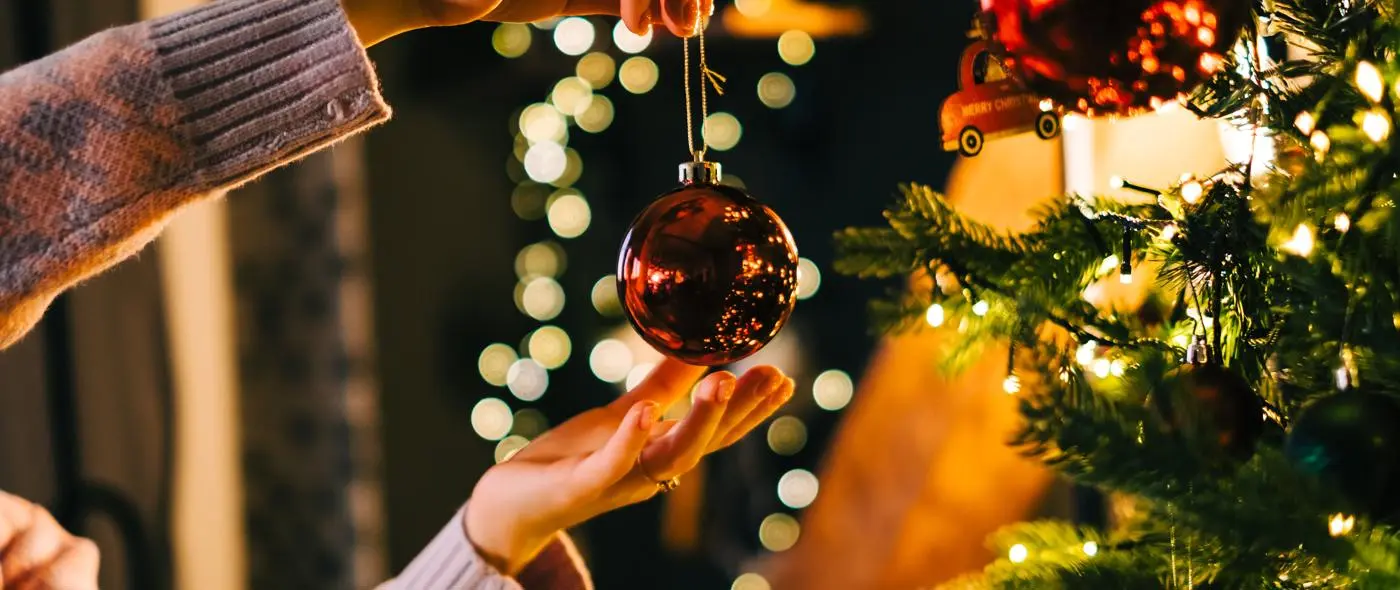 person decorating a Christmas Tree