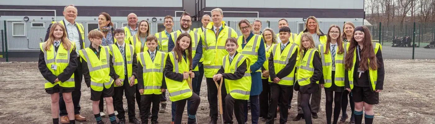 leader with a group of school children on a building site