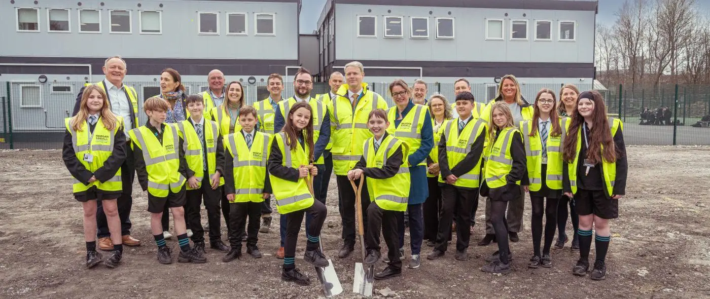 leader with a group of school children on a building site